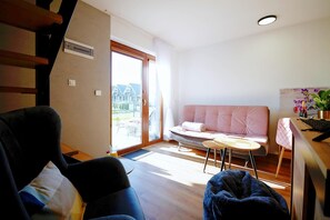 A modern living room with a sofa, a chair, a small table, and a staircase. - Comfortable and Spacious Holiday Home, Mielenko (Mielno)
