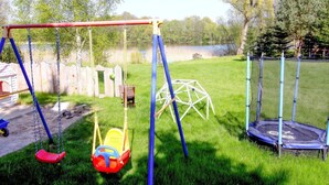 A playground with swings, a slide, and a trampoline. - Ferienwohnung, Zemitz (Zemitz)