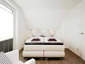 Une chambre à coucher avec un lit, une chaise et une fenêtre.