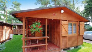 A wooden cabin with a porch, a small window, and a door. - Holiday House Near the Sea, Swimming Pool, Mielno (Mielno)