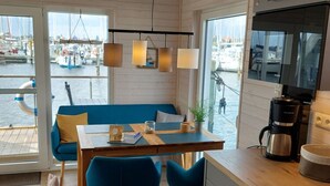 Una cocina moderna con una mesa de madera, sillas azules y una cafetera.