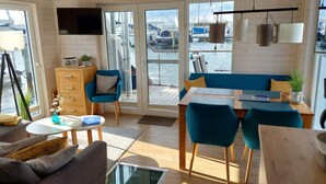 Un interior moderno con comedor, asientos y vistas al puerto deportivo.