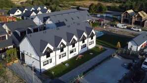 A modern residential building with a sloped roof and multiple windows. - Comfortable Holiday Homes With air Conditioning (Ustronie Morskie)