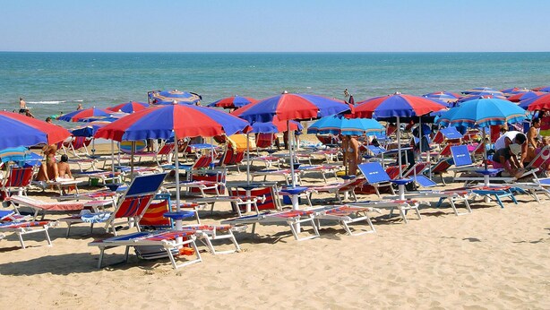A beach with rows of sun loungers and umbrellas. - Bungalow in a Resort in Lido del Sole With Terrace (Rodi Garganico)