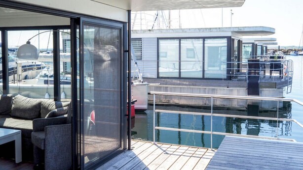 A modern outdoor seating area with a view of the marina. - Hausboot in Boltenhagen (Boltenhagen)