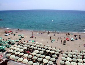 A beach with numerous umbrellas and people. - Pietra Ligure Beach Residence for 4 (Pietra Ligure)