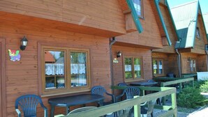 A wooden building with outdoor seating and windows. - Two-story Holiday Homes With Terraces (Mielno)
