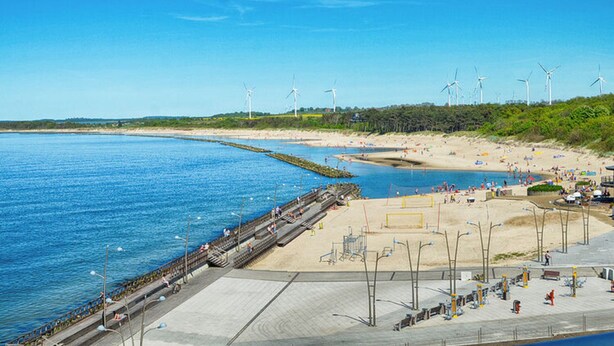 A coastal beach with wind turbines, a pier, and a sandy shore. - Comfortable Apartments Close to the Beach Darlowko (Darlowo)