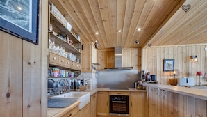 A wooden kitchen with a tiled backsplash, stainless steel appliances, and wooden cabinets. - Spacious Apartment 6 People · Balcony · Wifi in Tignes Le Lac (Tignes)
