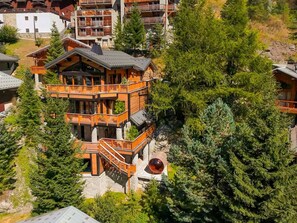 A multi-story lodge with balconies, surrounded by dense forest. - Luxury chalet with indoor pool and 5-star services in Tignes (Tignes)
