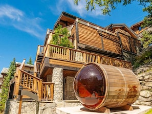Una cabaña de madera de varios pisos con una estructura cilíndrica grande al frente.