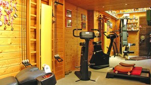 Une salle de sport équipée de matériel d’exercice, avec des murs en bois et des trophées.