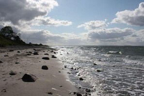 Una platja amb roques disperses i un cel serè.