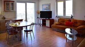 Un salon moderne comprenant un canapé, une table basse en verre et un coin repas avec des chaises et une table.
