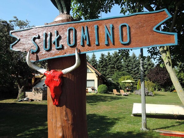Une enseigne en bois portant le mot « SULOMINO » et ornée d’une tête de taureau rouge.