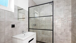 A modern bathroom with a glass-enclosed shower, a white sink, and a toilet. - Comfortable Cottages, Jezierzany (Postomino)