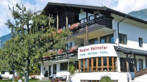 Un bâtiment sur lequel on peut lire l’inscription suivante : « Pension Wallöfer Zimmer – Espace bien-être – Appartements de vacances ».