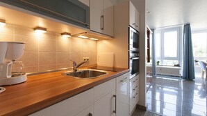 Una cucina moderna con lavello in acciaio inossidabile, macchina del caffè e forno integrato.