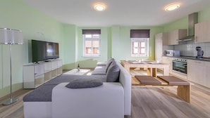 A modern apartment with a living room, dining area, and kitchen. - Ferienwohnung Remise, Wernigerode (Wernigerode)