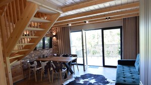 A wooden interior with a staircase, a dining area, and a sofa. - Holiday Home With Pool and Sauna (Chmielno)