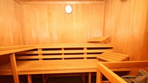 A sauna room with wooden benches and a red bench with a towel. - Ferienwohnung im Haus Schiefertal, Wieda (Walkenried)