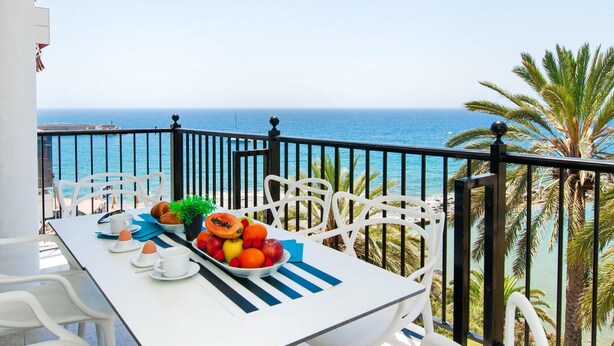 A balcony with a table set for breakfast, overlooking the sea. - Apartment Beach Front, Arguineguin (Mogan)