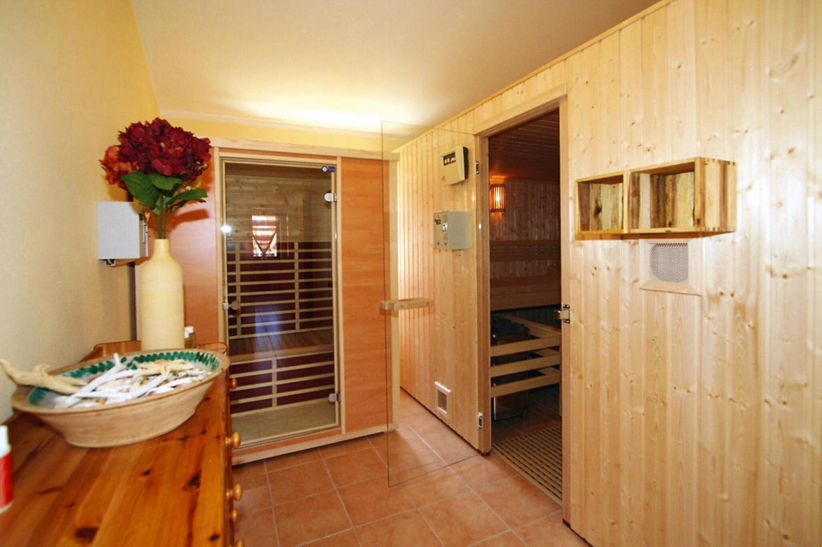 A wooden interior with a sliding glass door leading to a balcony, a wooden cabinet with a vase, and a tiled floor.