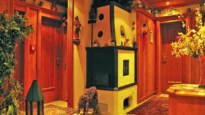 Une pièce chaleureuse avec une cheminée, des murs en bois et un grand tapis.