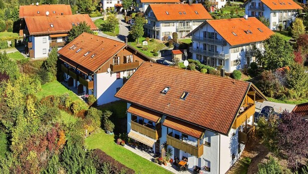A residential area with houses featuring red-tiled roofs, surrounded by greenery and hills. - Ferienwohnung in Bodenmais am Grossen Arber (Bodenmais)