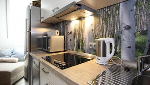 A modern kitchen with a built-in stove, a kettle, and a microwave. - Appartement Jagdschlosschen, Bad Sachsa (Bad Sachsa)