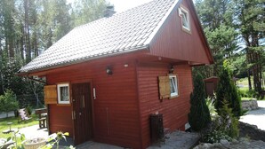A small wooden cabin with a sloped roof, a front door, and a small window.