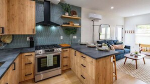 Une cuisine moderne avec des meubles en bois, un îlot central et une cuisinière intégrée.