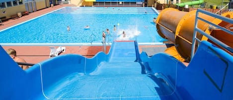 A swimming pool with a water slide and a large water pump.