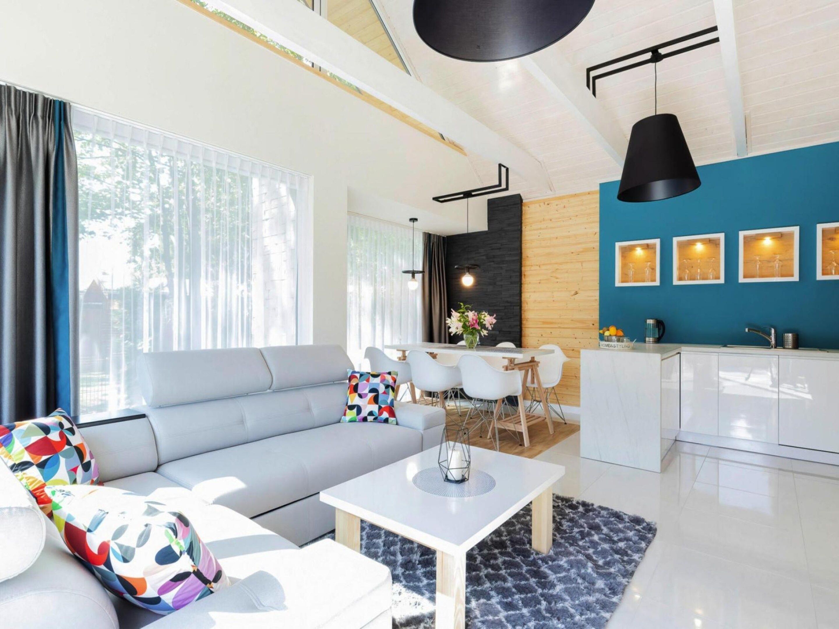 Een moderne woonkamer met een bank, salontafel en eethoek.