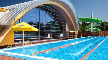 A swimming pool with a clear blue water surface, surrounded by a brick deck.
