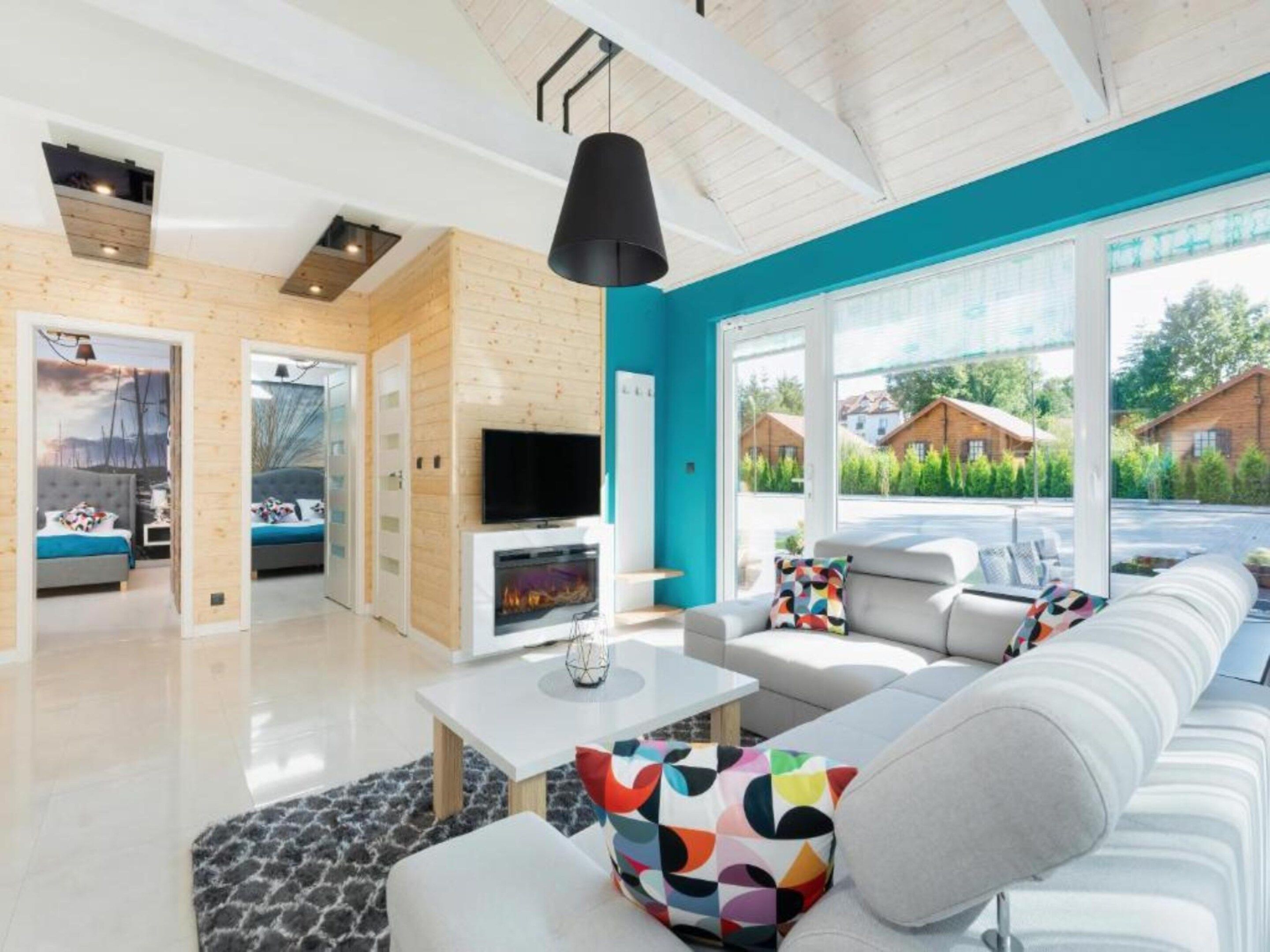 A modern living room with a fireplace, a sofa set, and a television.