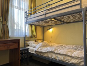 En våningssäng med ett skrivbord och en lampa.