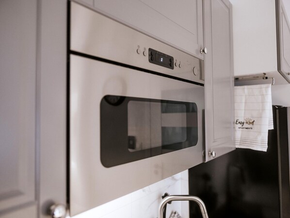 A kitchen with stainless steel appliances, including an oven and a microwave.