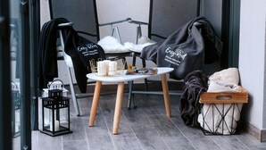 Un petit espace extérieur aménagé avec deux chaises, une table et une lanterne.
