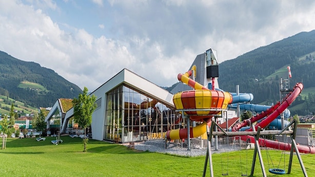 A playground with slides and a climbing structure, set against a mountainous backdrop. - Apartment House Isegrim, Altenmarkt (Altenmarkt im Pongau)