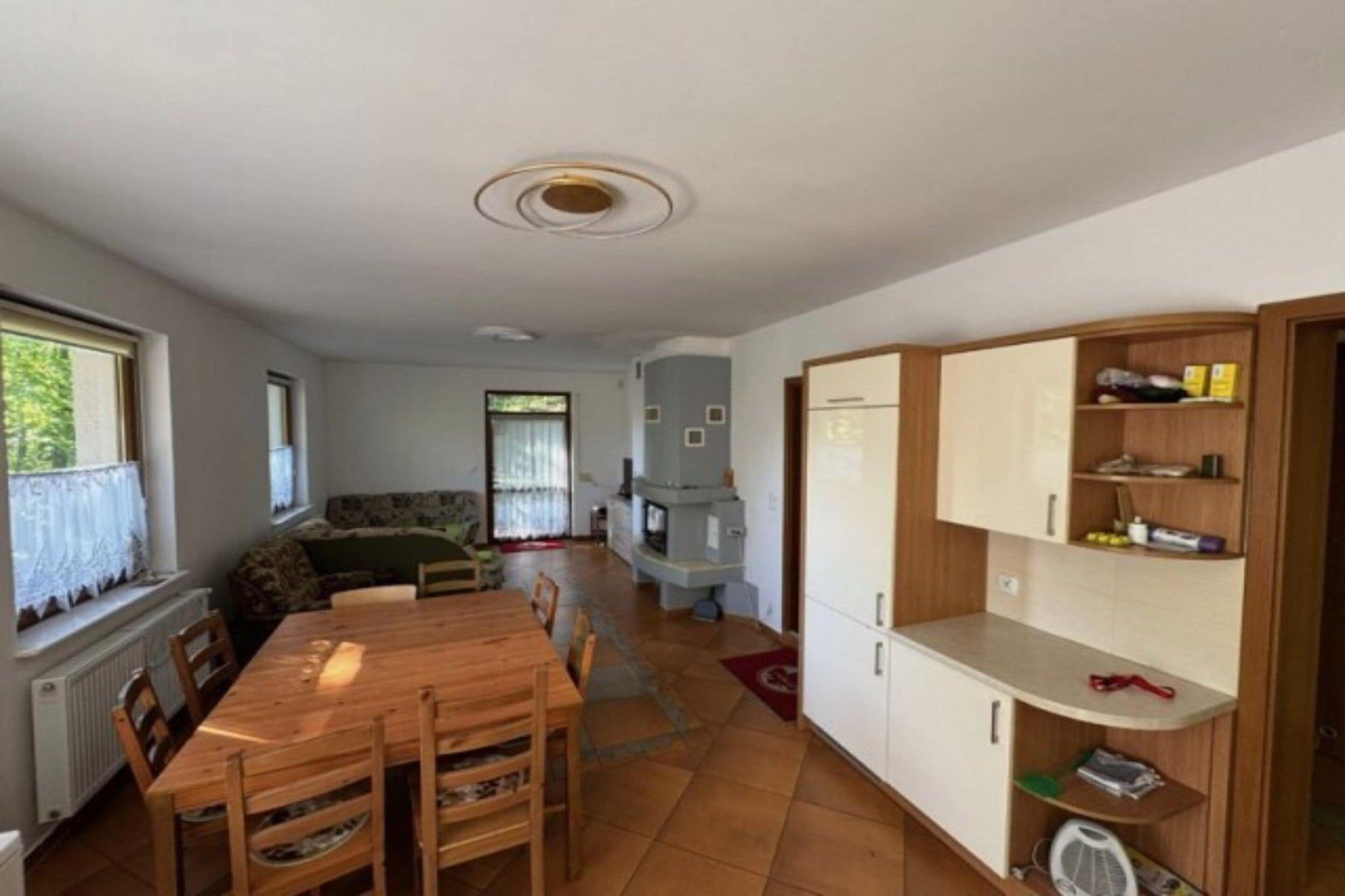 Un espacio habitable compacto con comedor, kitchenette y zona de estar con sofá.