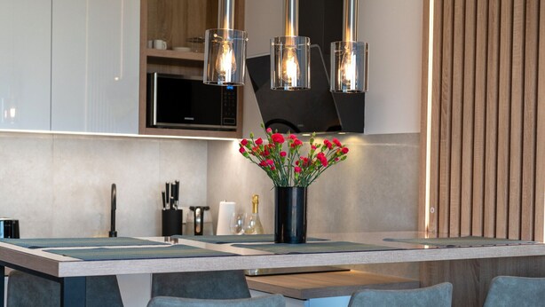 A modern kitchen with a central island, bar stools, and pendant lighting. - Apartment in Rewal Near Baltic Sea Beach (Rewal)