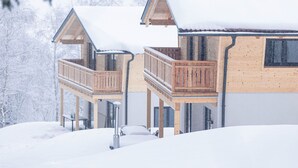 A wooden cabin with a balcony and a covered porch, surrounded by snow. - Chalet Arber in St.englmar With its own Hottube (Sankt Englmar)