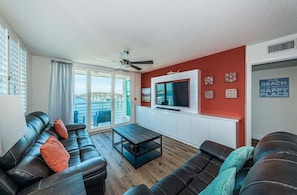 Una sala de estar moderna con un conjunto de sofá, una mesa de centro y un televisor montado en una pared roja.