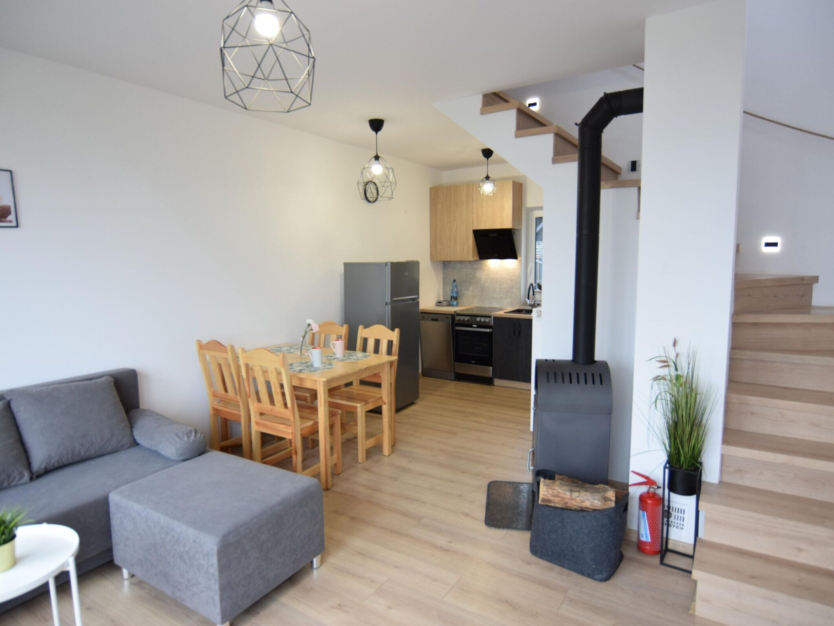 Un appartement moderne comprenant un salon, un coin repas, une cuisine et un escalier.
