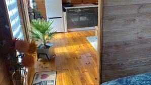 A wooden interior with a kitchen area, a dining table with a placemat, and a potted plant. - Holiday Home in Stepnica With Sauna & Jacuzzi (Stepnica)