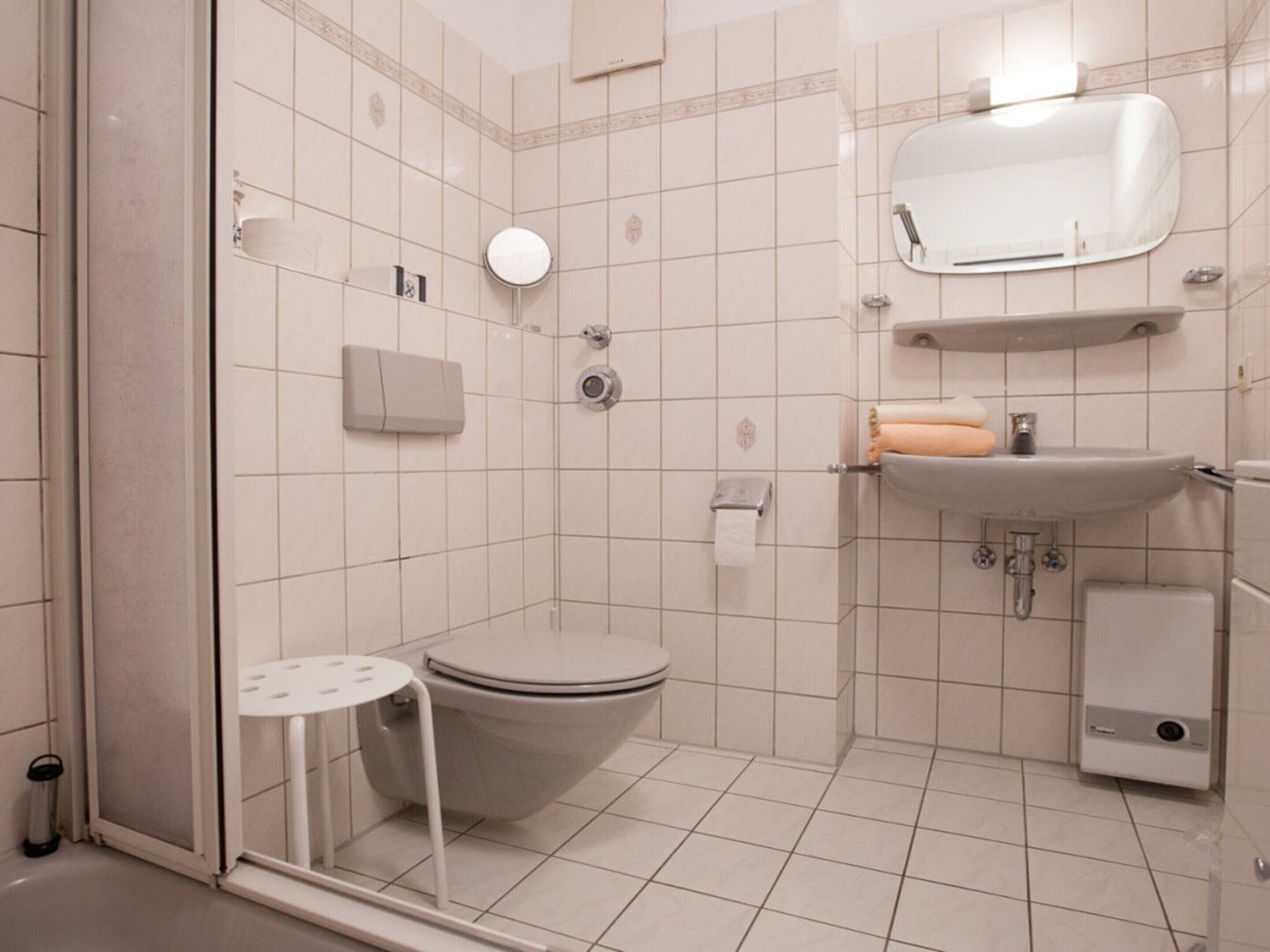 Un baño moderno con inodoro, lavamanos y zona de ducha.
