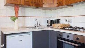 A kitchen with wooden cabinets, a dishwasher, a stove, and a sink.