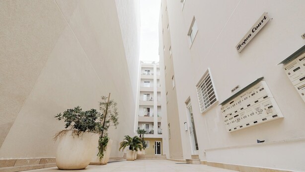 A clean, modern building with a sign reading "Europa Court" and a series of air conditioning units on the wall. - Modern 1-bedroom apartment ideally located near Balluta Bay and Sliema’s promenade. Includes a sofa bed, full kitchen, Wi-Fi, and A/C — everything you need for a comfortable stay close to shops, beaches, and restaurants. (Tas-Sliema)