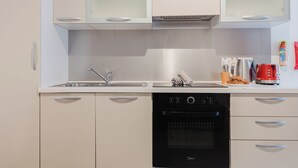 A modern kitchen with a dishwasher, a sink, and a stove. There are cabinets above the sink and a coffee maker on the counter. - Modern 1-bedroom apartment ideally located near Balluta Bay and Sliema’s promenade. Includes a sofa bed, full kitchen, Wi-Fi, and A/C — everything you need for a comfortable stay close to shops, beaches, and restaurants. (Tas-Sliema)